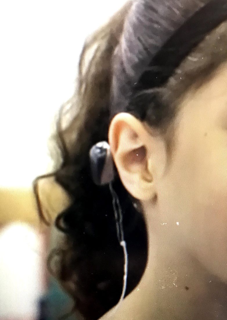 Close view of a child's hearing aid in place behind the ear.